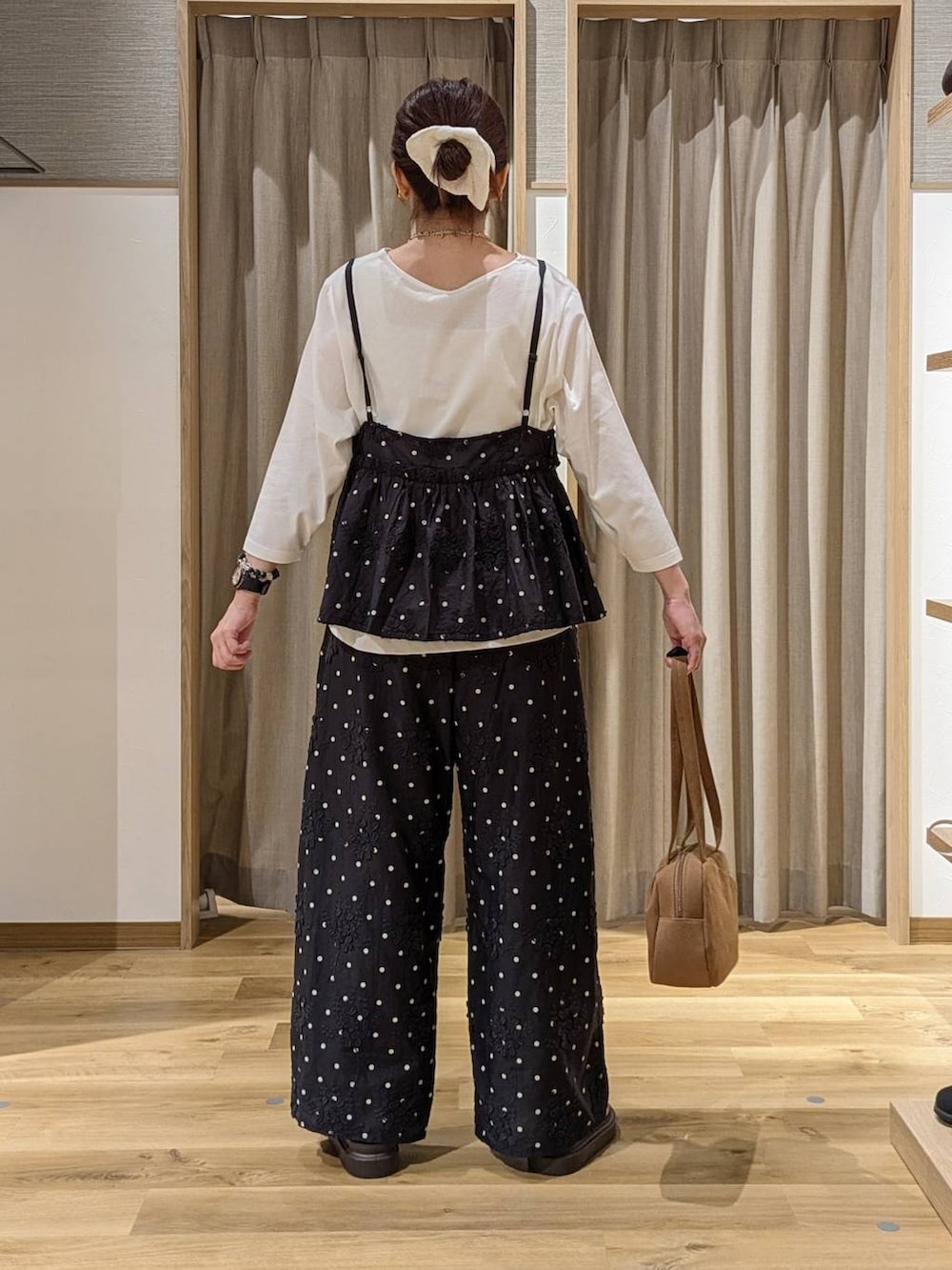 ブラウン系のショルダーバッグ、ブラック系のその他パンツ、ブラック系のキャミソールを着用したレディースの夏コーディネートの3枚目の写真