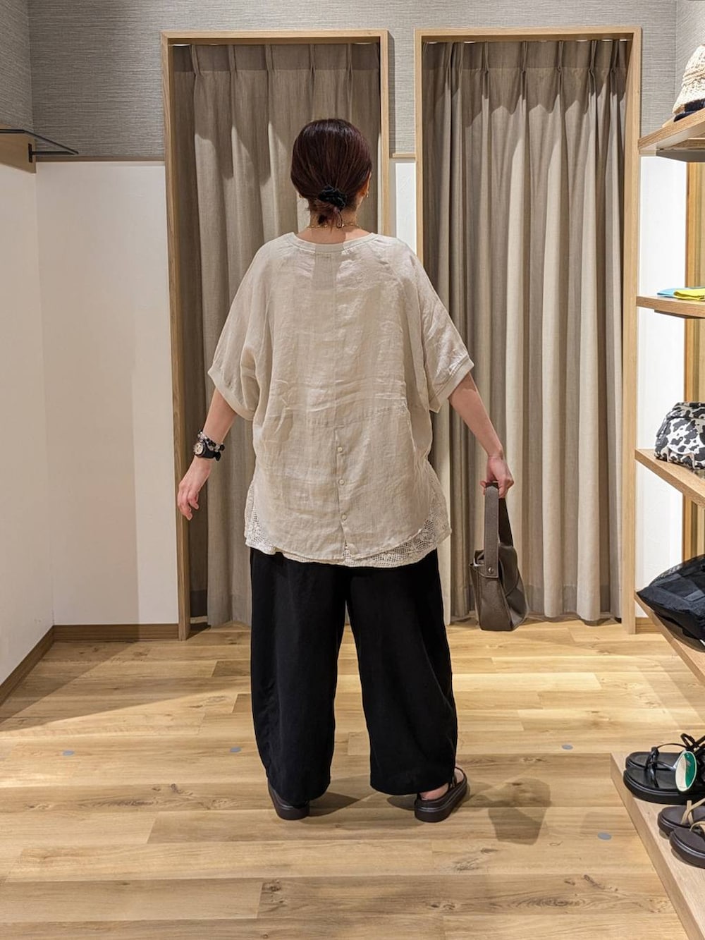 ブラウン系のサンダル、ホワイト系のベスト、ブラック系のその他パンツを着用したレディースの夏コーディネートの2枚目の写真