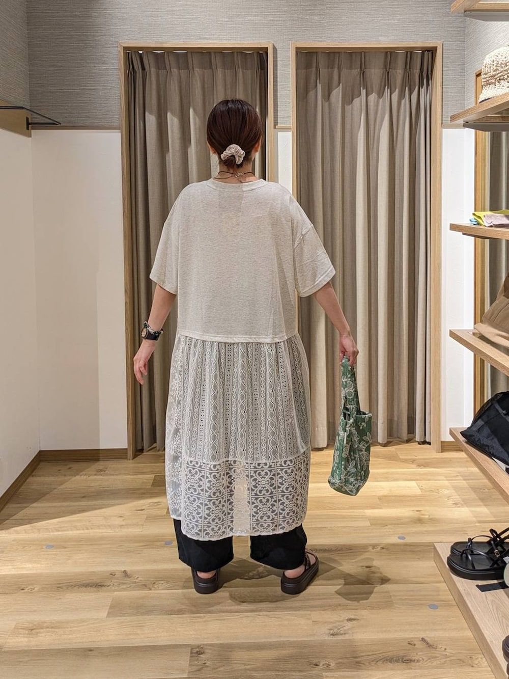 ベージュ系のワンピース、ブラウン系のサンダル、グリーン系のトートバッグを着用したレディースの夏コーディネートの2枚目の写真
