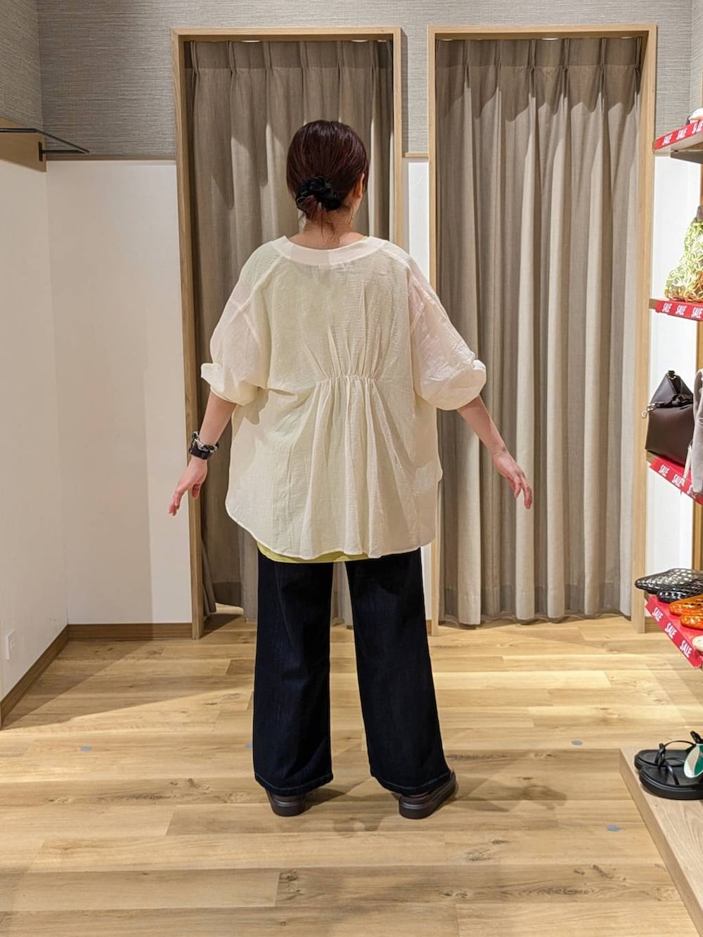 ブラウン系のサンダル、ブルー系のデニムパンツを着用したレディースの夏コーディネートの2枚目の写真