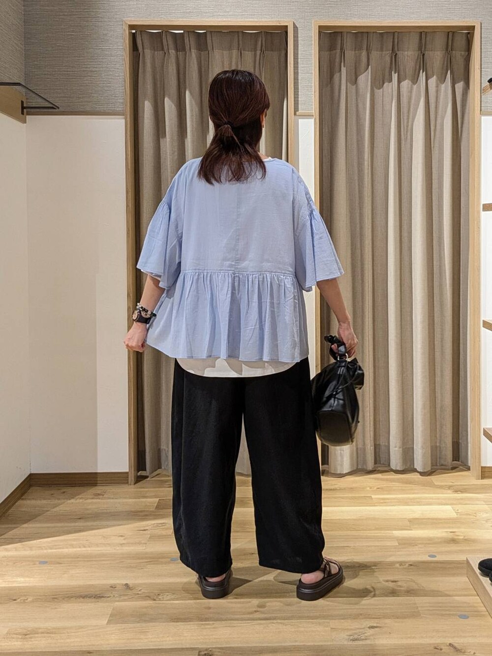 ブラウン系のサンダル、ブラック系のその他パンツ、ブラック系のトートバッグを着用したレディースの夏コーディネートの2枚目の写真