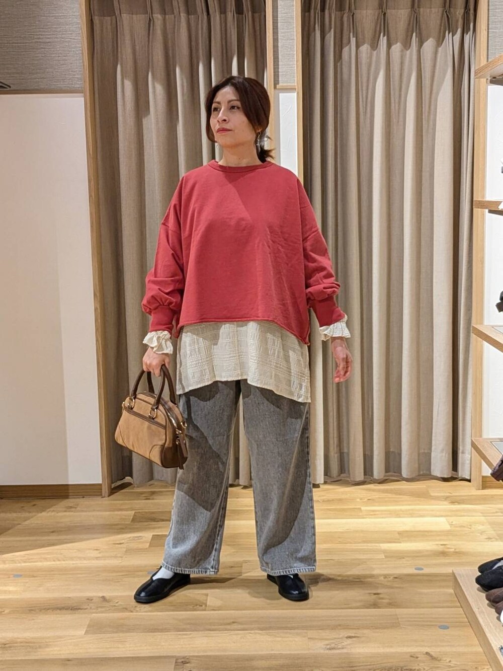 グレー系のデニムパンツ、ブラウン系のショルダーバッグ、ホワイト系のシャツ/ブラウスを着用したレディースの冬コーディネートの2枚目の写真