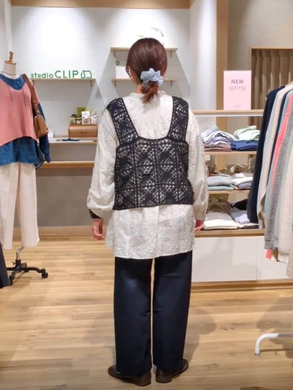 ブラック系のベスト、ブルー系のその他パンツ、ブラウン系のトートバッグを着用したレディースの春コーディネートの2枚目の写真