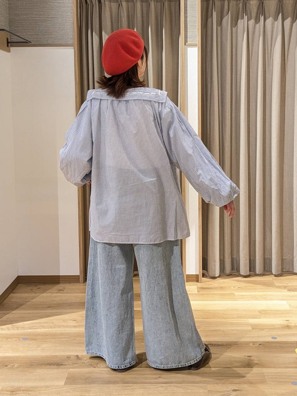 ブルー系のデニムパンツ、ブラウン系のショルダーバッグ、ブラウン系のローファーを着用したレディースの冬コーディネートの2枚目の写真