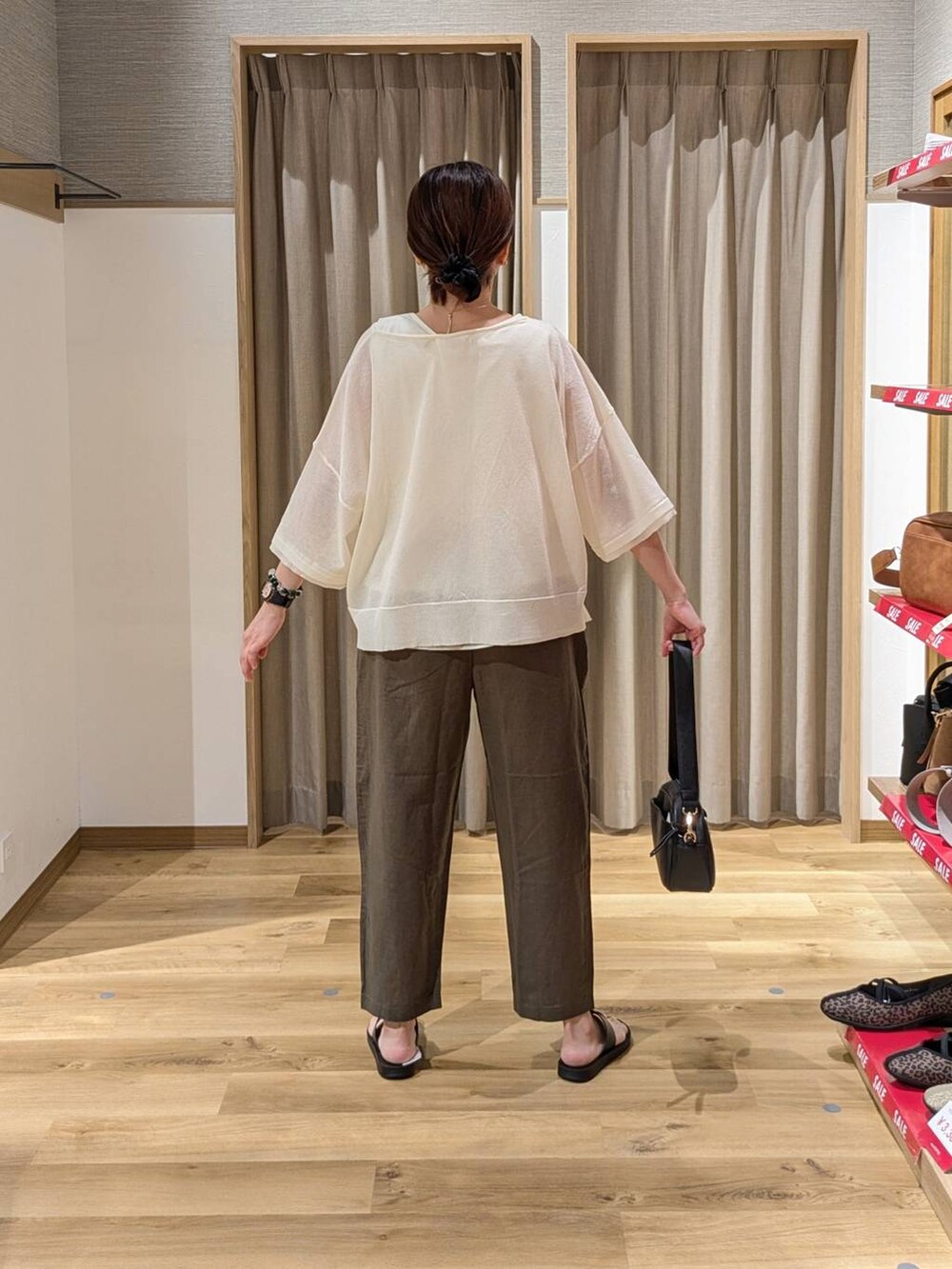 ブラック系のショルダーバッグ、ブラック系のサンダル、グリーン系のその他パンツを着用したレディースの夏コーディネートの2枚目の写真