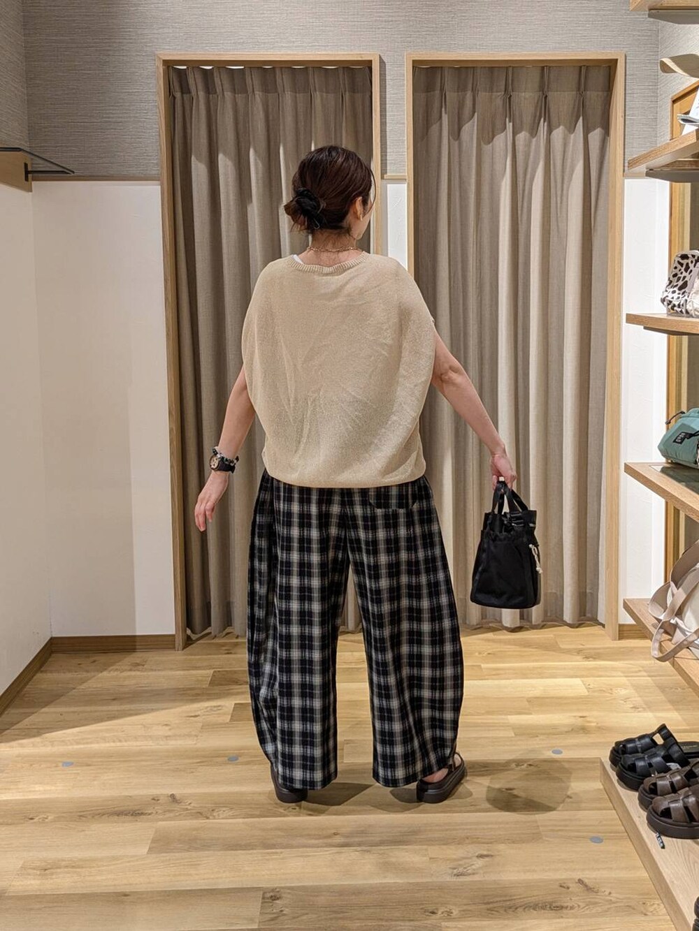 ブラウン系のサンダル、ブラック系のその他パンツ、ベージュ系のニット/セーターを着用したレディースの夏コーディネートの2枚目の写真