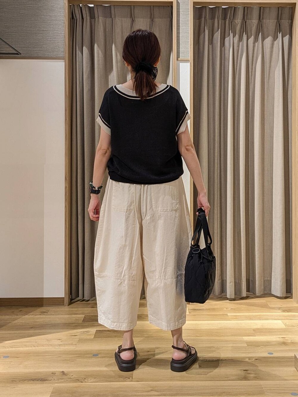 ブラック系のニット/セーター、ブラウン系のサンダル、ホワイト系のその他パンツを着用したレディースの夏コーディネートの3枚目の写真