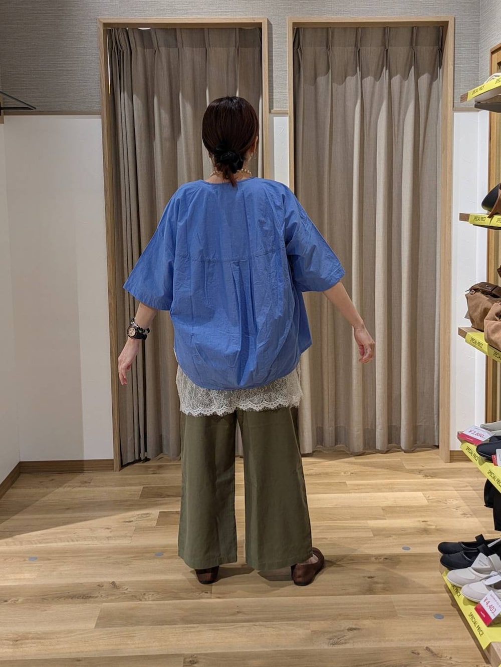 ブルー系のショルダーバッグ、ブラウン系のパンプス、グリーン系のその他パンツを着用したレディースの春コーディネートの2枚目の写真