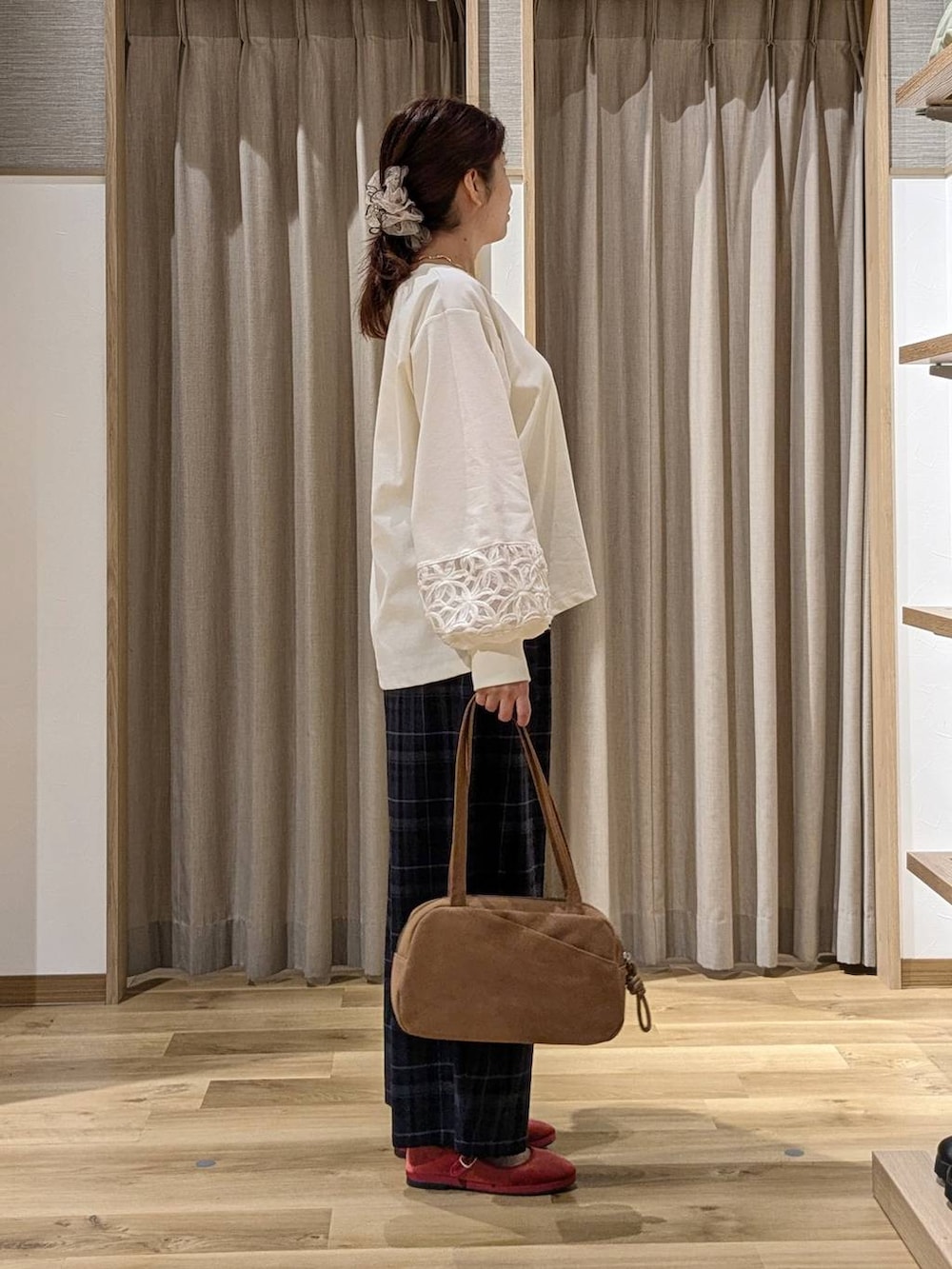 ブラウン系のショルダーバッグ、レッド系のその他シューズ、ホワイト系のTシャツ/カットソーを着用したレディースの秋コーディネートの2枚目の写真