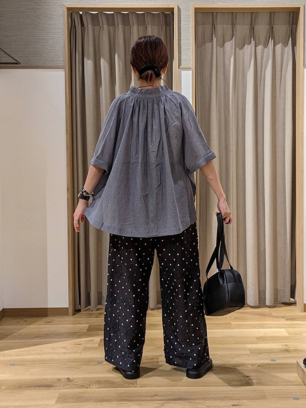 ブラック系のショルダーバッグ、ブラック系のその他パンツ、ブルー系のシャツ/ブラウスを着用したレディースの夏コーディネートの3枚目の写真