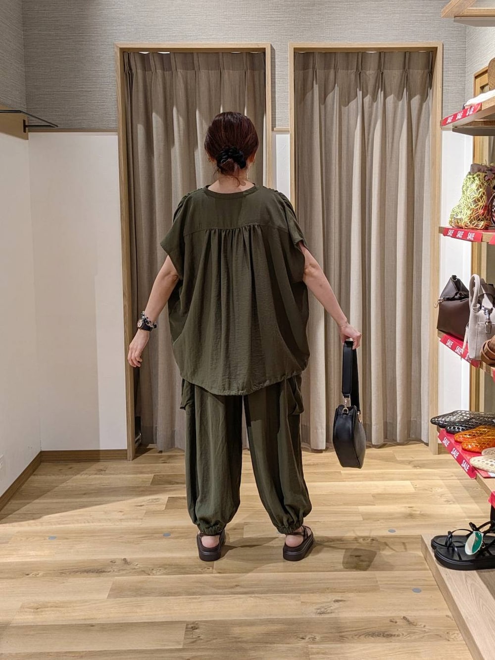グリーン系のカーゴパンツ、グリーン系のシャツ/ブラウス、ブラック系のショルダーバッグを着用したレディースの夏コーディネートの2枚目の写真