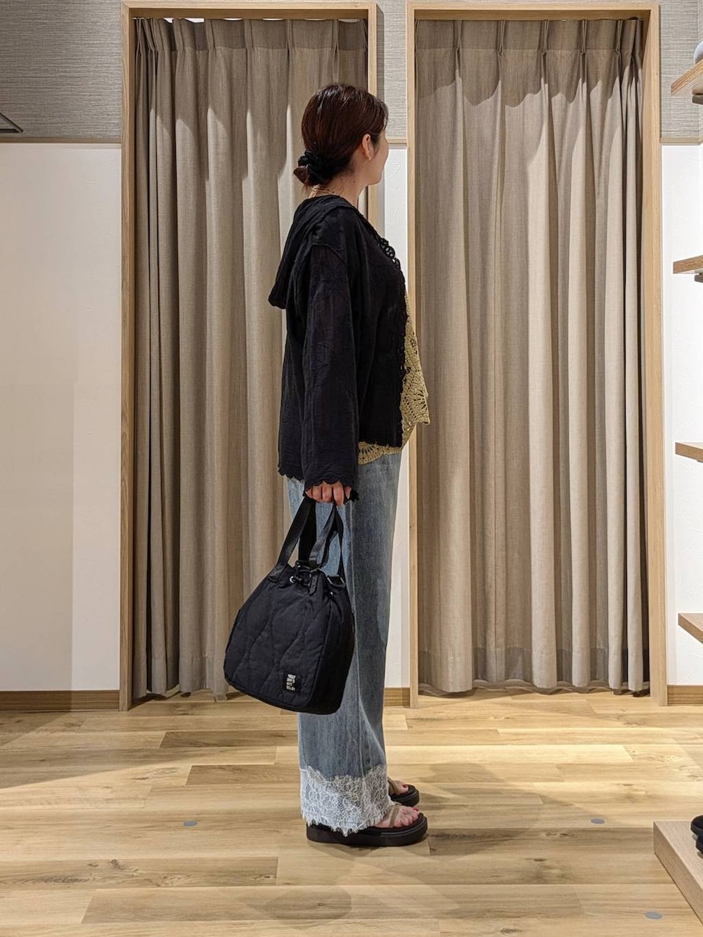 ブルー系のデニムパンツ、ブラック系のシャツ/ブラウス、ベージュ系のサンダルを着用したレディースの夏コーディネートの2枚目の写真