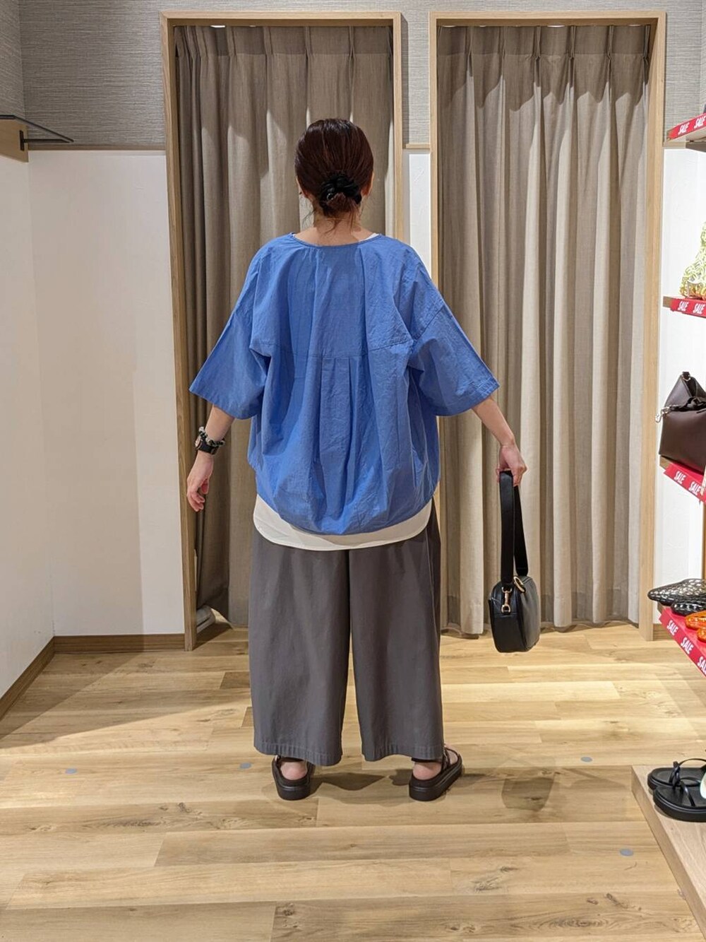 ブラック系のショルダーバッグ、その他のその他パンツ、ブラウン系のサンダルを着用したレディースの夏コーディネートの2枚目の写真