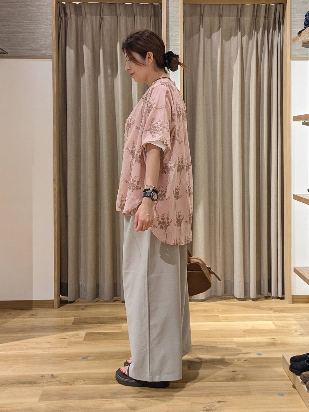 ブラウン系のショルダーバッグ、ピンク系のシャツ/ブラウス、ブラウン系のサンダルを着用したレディースの夏コーディネートの2枚目の写真