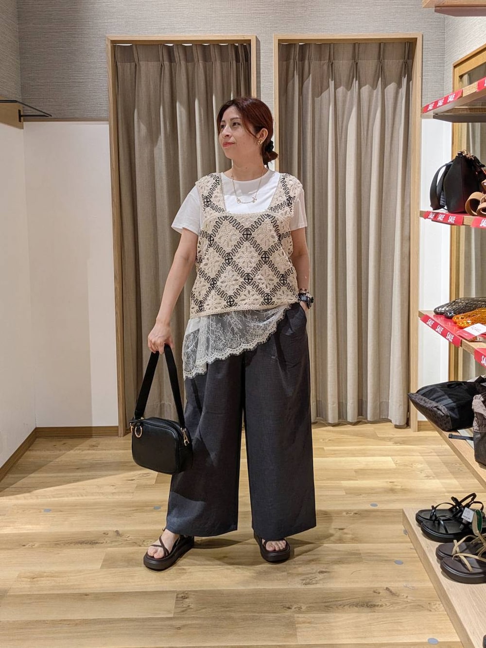 その他のベスト、ブラック系のショルダーバッグ、ブラウン系のサンダルを着用したレディースの夏コーディネートの2枚目の写真