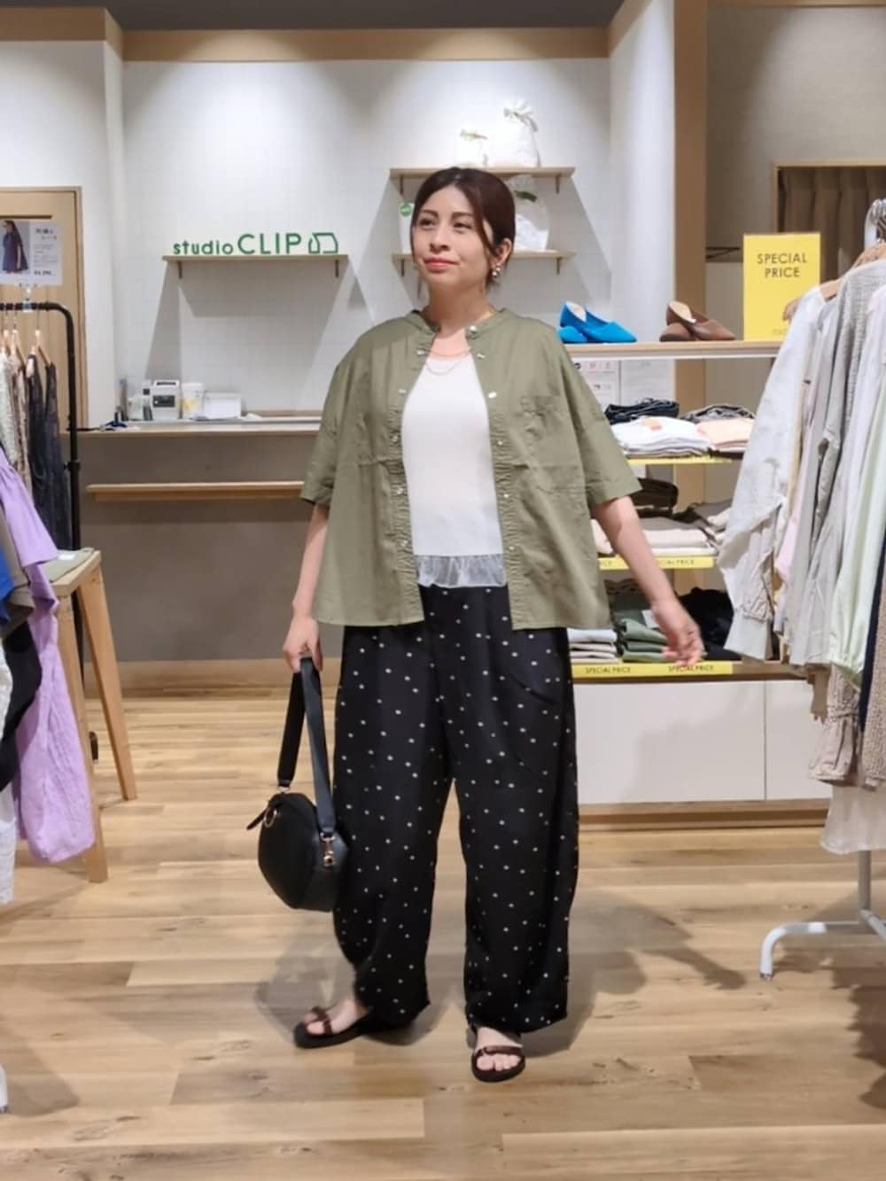 ブラック系のショルダーバッグ、ブラウン系のサンダル、その他のその他パンツを着用したレディースの春コーディネートの2枚目の写真