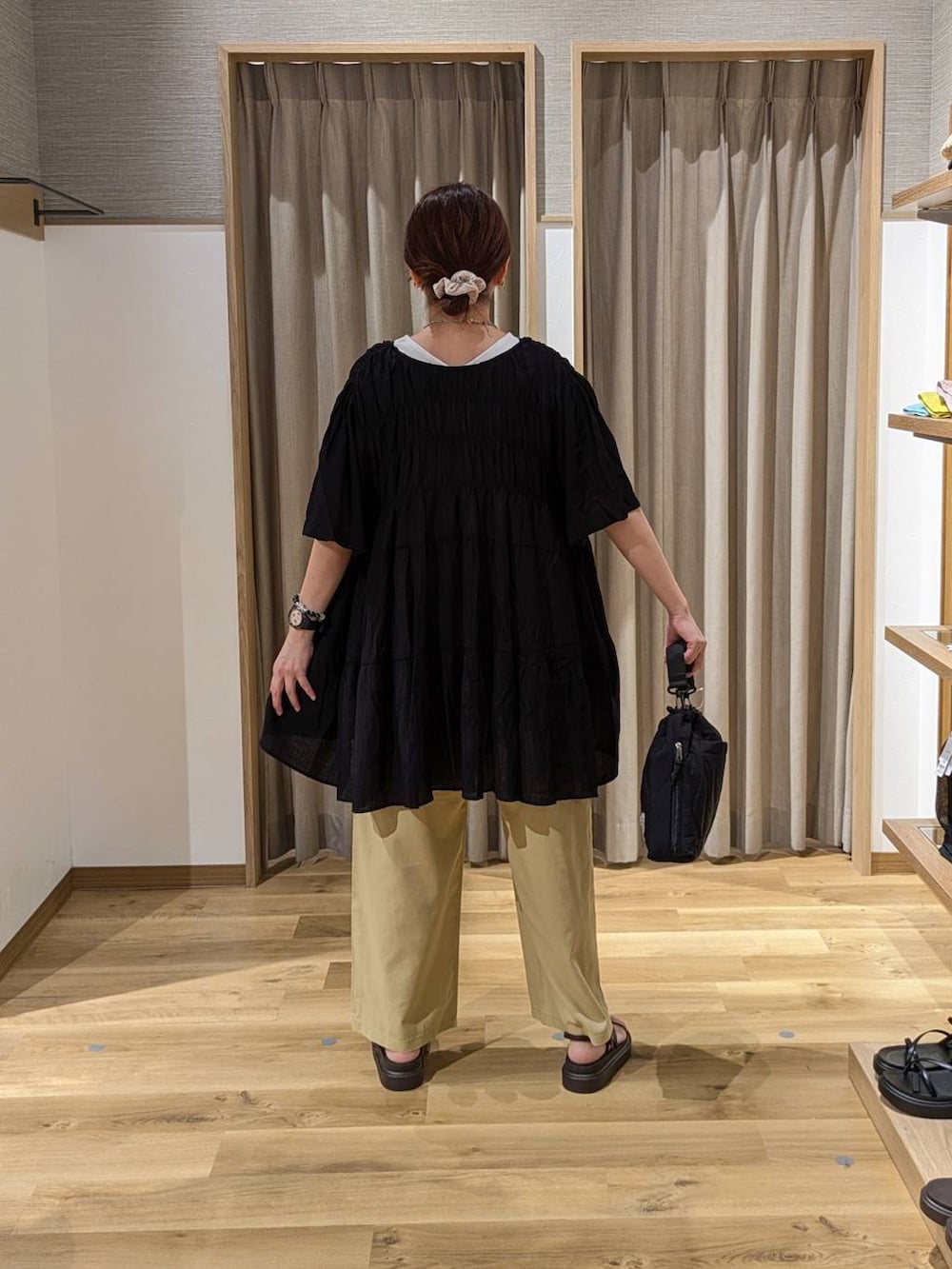 ブラウン系のサンダル、ブラック系のトートバッグ、ベージュ系のその他パンツを着用したレディースの夏コーディネートの2枚目の写真