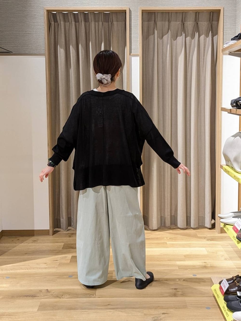 ブラック系のカーディガン/ボレロ、ブラック系のショルダーバッグ、グレー系のパンプスを着用したレディースの春コーディネートの2枚目の写真