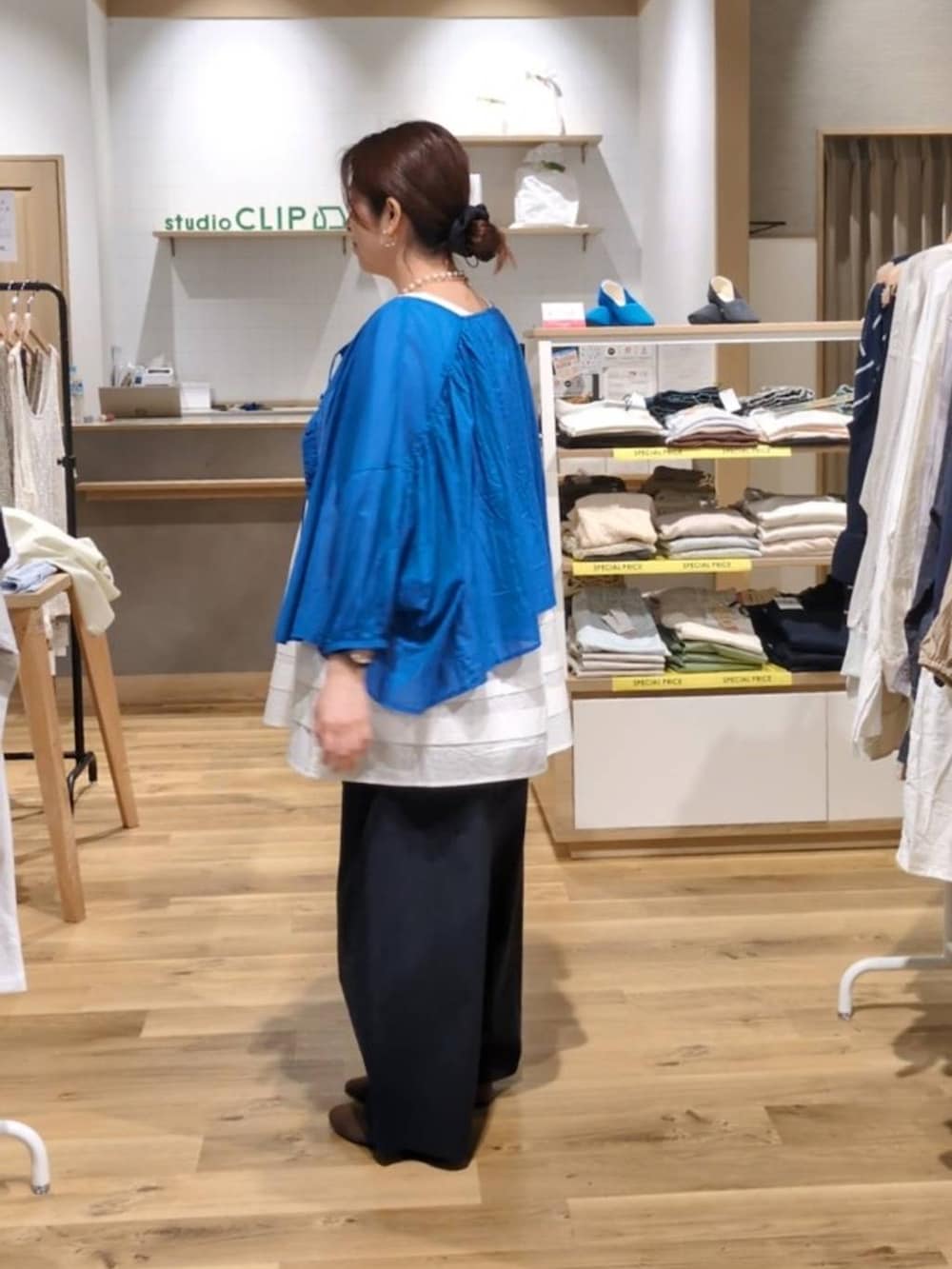 ブラウン系のショルダーバッグ、ブラウン系のパンプス、ブルー系のその他パンツを着用したレディースの春コーディネートの2枚目の写真