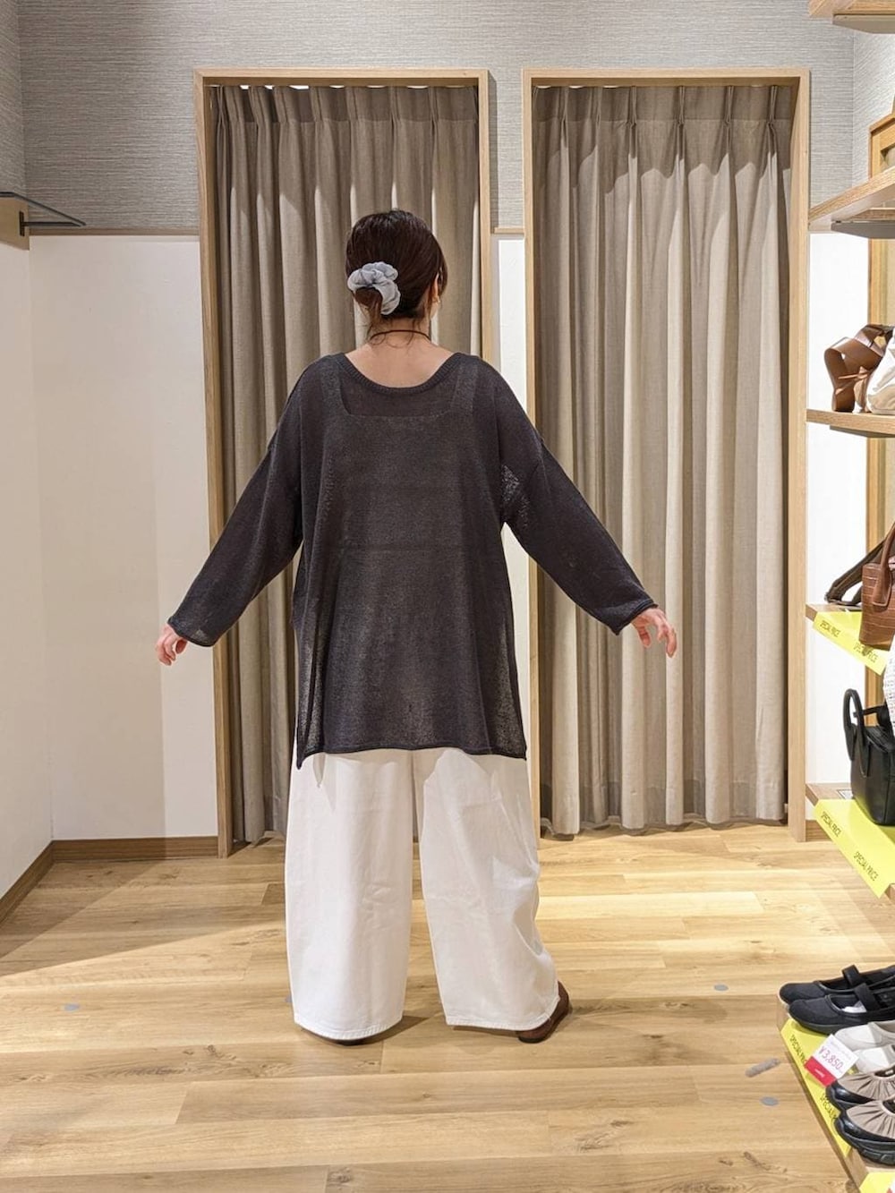 ホワイト系のデニムパンツ、ブラウン系のトートバッグ、ベージュ系のタンクトップを着用したレディースの春コーディネートの2枚目の写真