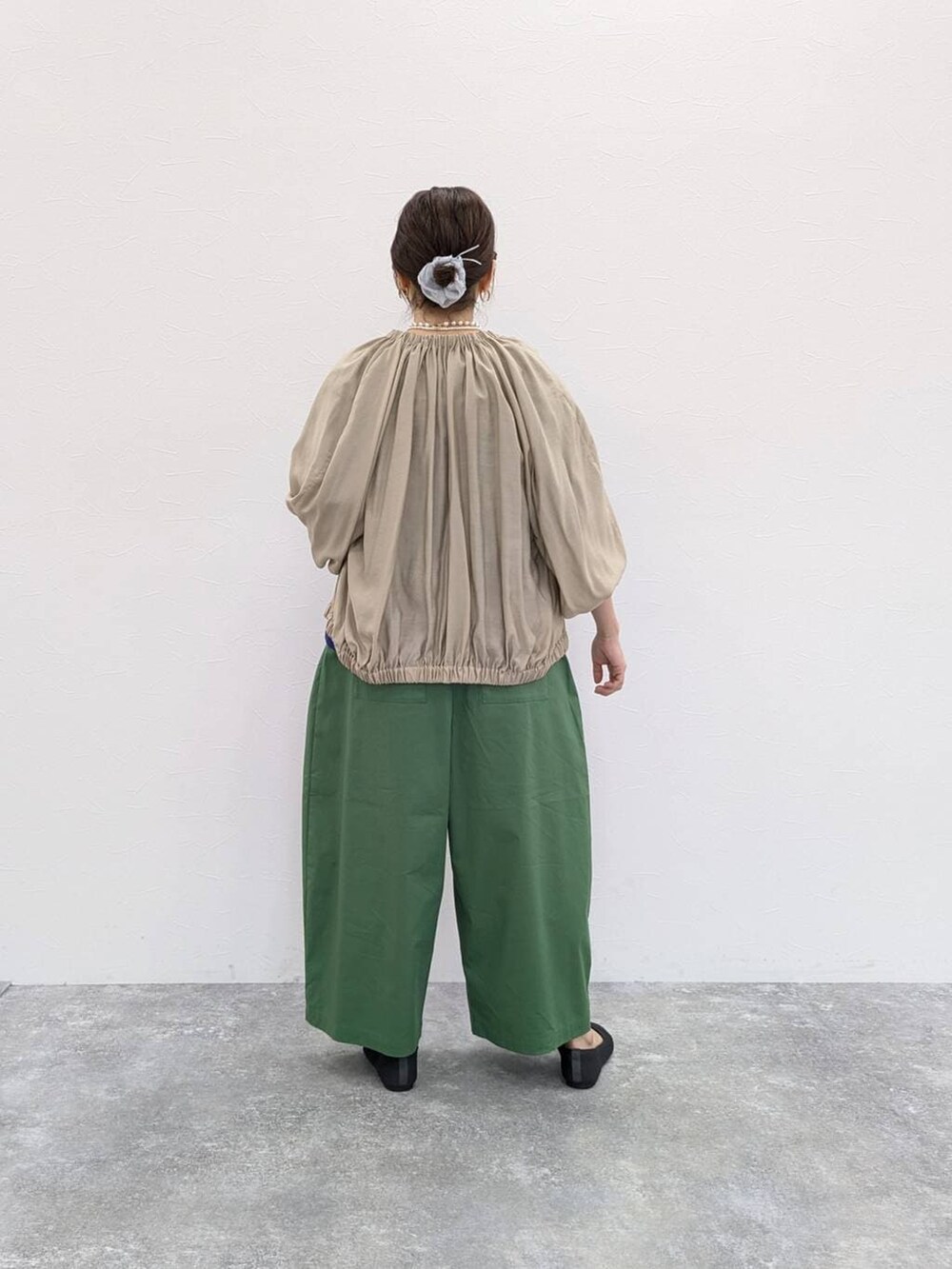 グレー系のパンプス、ベージュ系のブルゾン、その他のTシャツ/カットソーを着用したレディースの春コーディネートの2枚目の写真