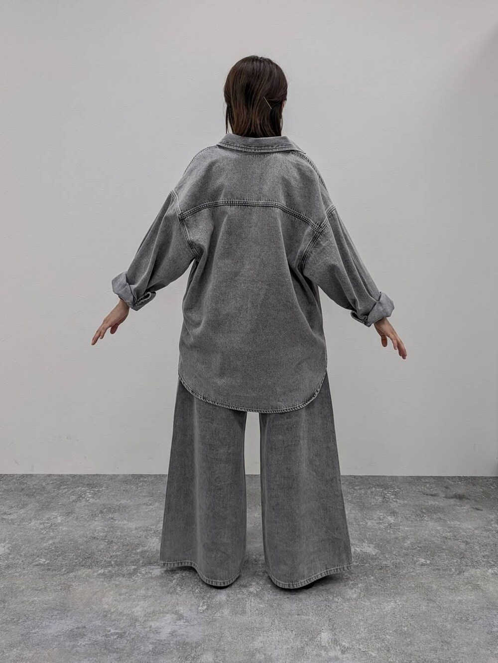 ホワイト系のTシャツ/カットソー、ブラック系のパンプス、グレー系のデニムパンツを着用したレディースの冬コーディネートの2枚目の写真