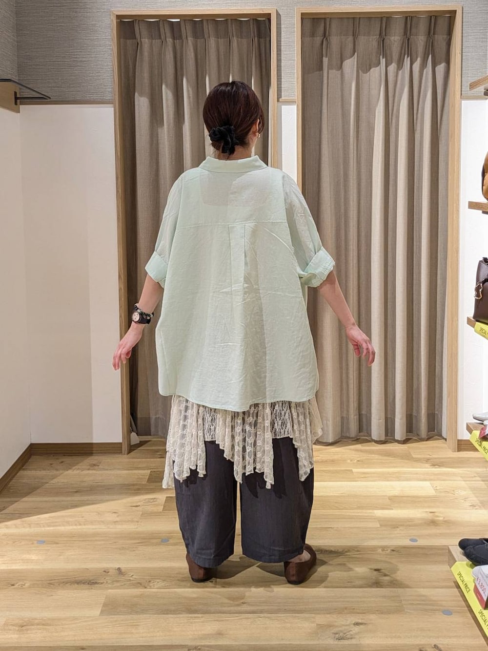 グリーン系のシャツ/ブラウス、ブラウン系のパンプス、ベージュ系のワンピースを着用したレディースの春コーディネートの2枚目の写真
