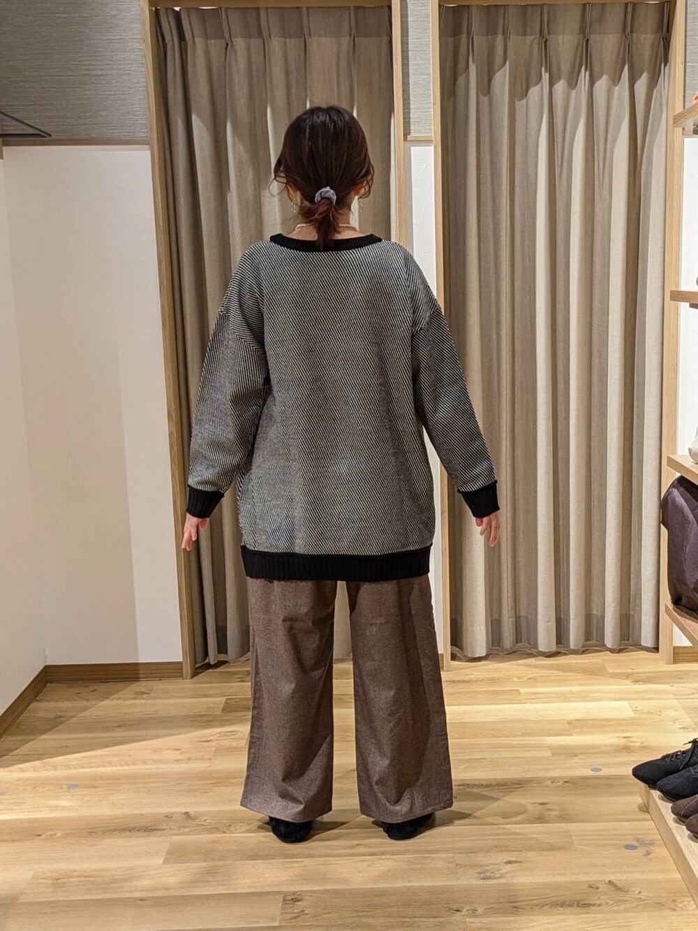 ブラック系のニット/セーター、ブラウン系のその他パンツ、ブラック系のショルダーバッグを着用したレディースの冬コーディネートの2枚目の写真