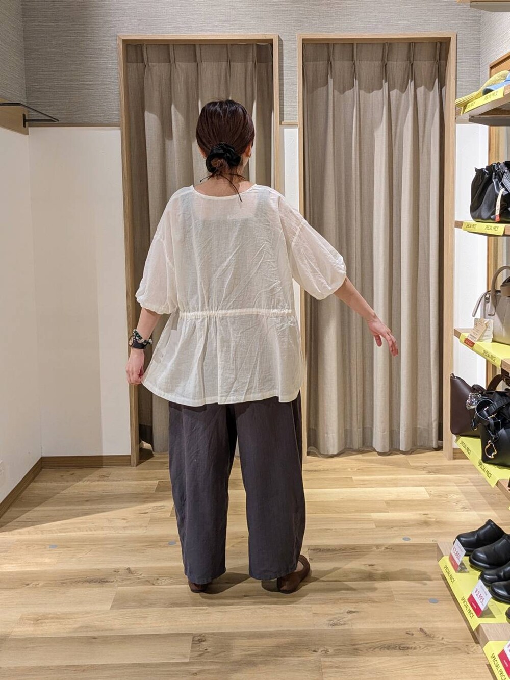 ブラウン系のショルダーバッグ、ブラウン系のパンプス、ブラック系のタンクトップを着用したレディースの夏コーディネートの2枚目の写真
