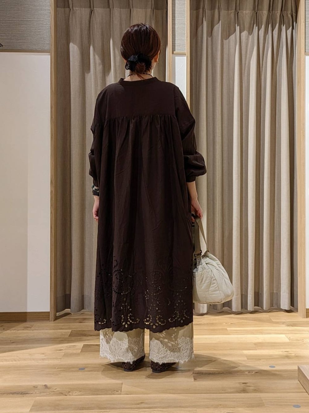 ベージュ系のデニムパンツ、ブラウン系のワンピース、ブラウン系のパンプスを着用したレディースの秋コーディネートの3枚目の写真