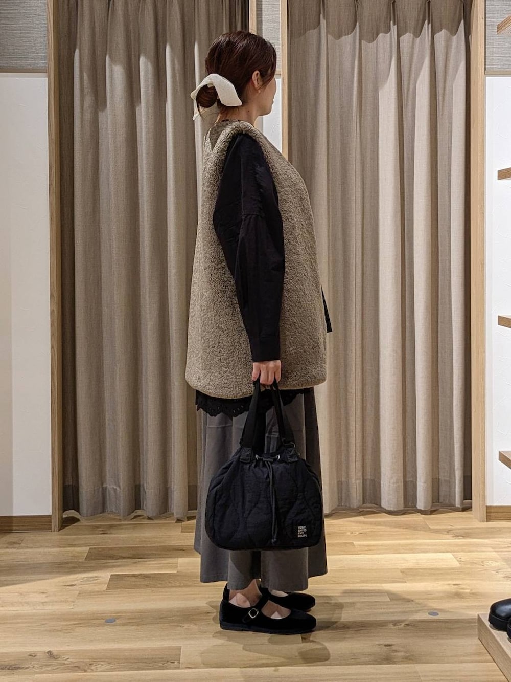 グレー系のチノパンツ、ブラック系のその他シューズ、ブラック系のシャツ/ブラウスを着用したレディースの秋コーディネートの2枚目の写真