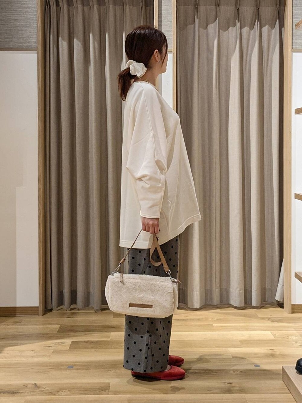 レッド系のその他シューズ、ベージュ系のショルダーバッグ、グレー系のその他パンツを着用したレディースの秋コーディネートの2枚目の写真