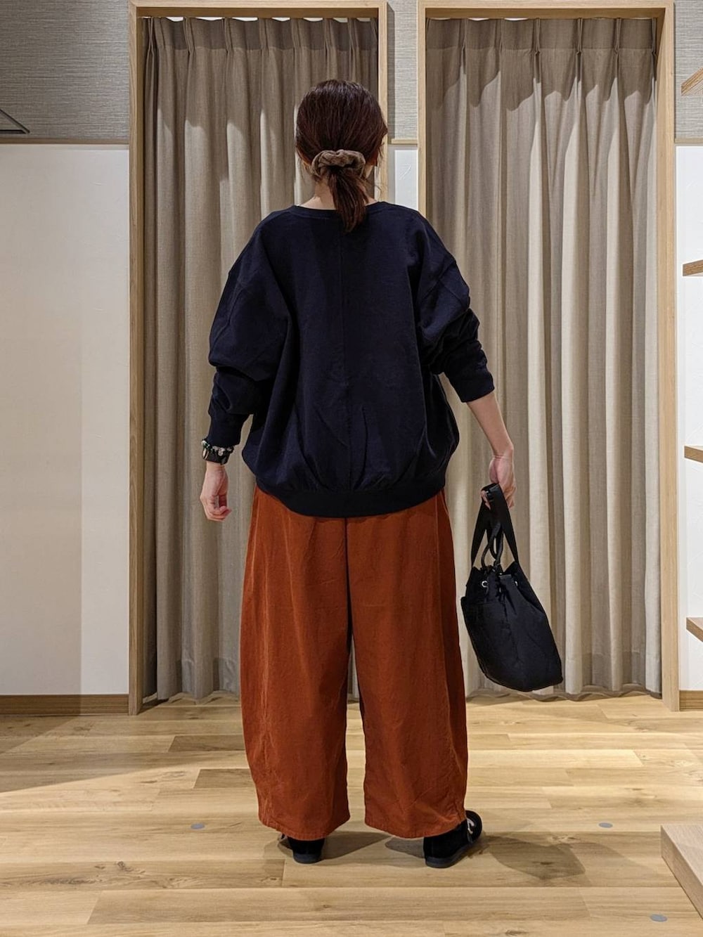 オレンジ系のその他パンツ、ブラック系のその他シューズ、ブルー系のスウェットを着用したレディースの秋コーディネートの2枚目の写真