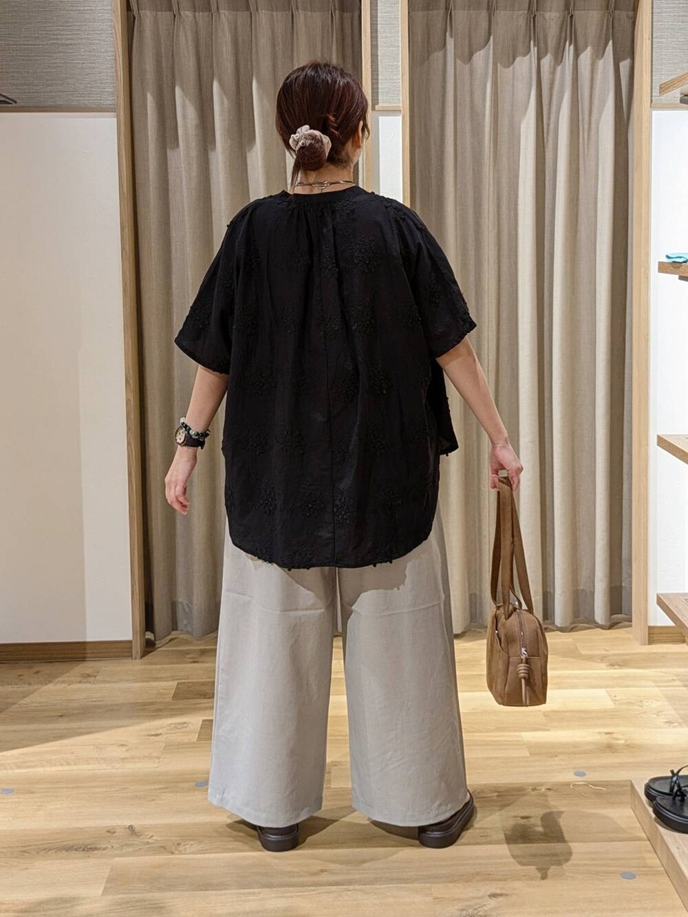 ブラウン系のショルダーバッグ、ブラウン系のサンダル、グレー系のその他パンツを着用したレディースの夏コーディネートの2枚目の写真