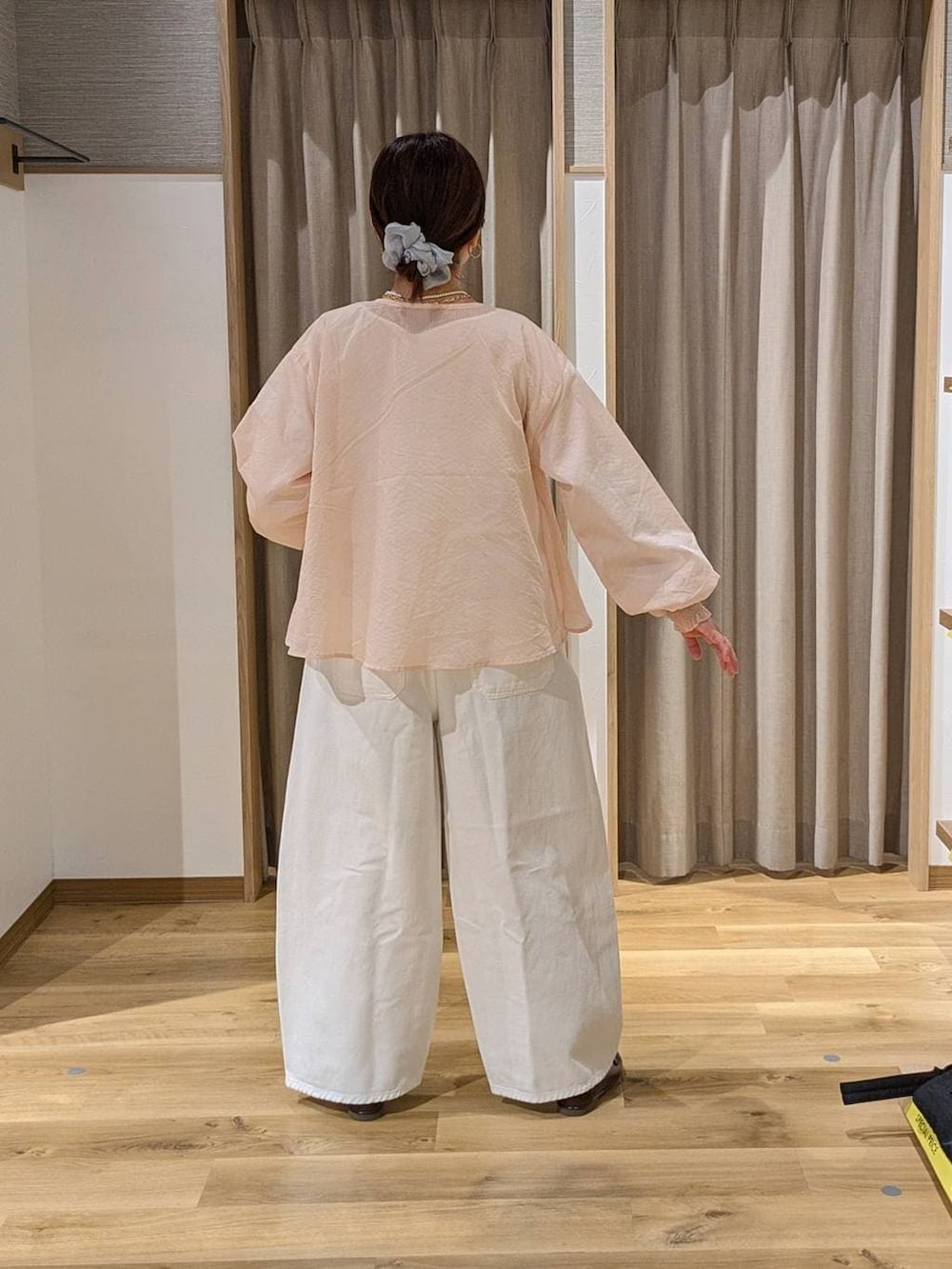 ホワイト系のデニムパンツ、ブラウン系のトートバッグ、ブラウン系のローファーを着用したレディースの春コーディネートの3枚目の写真