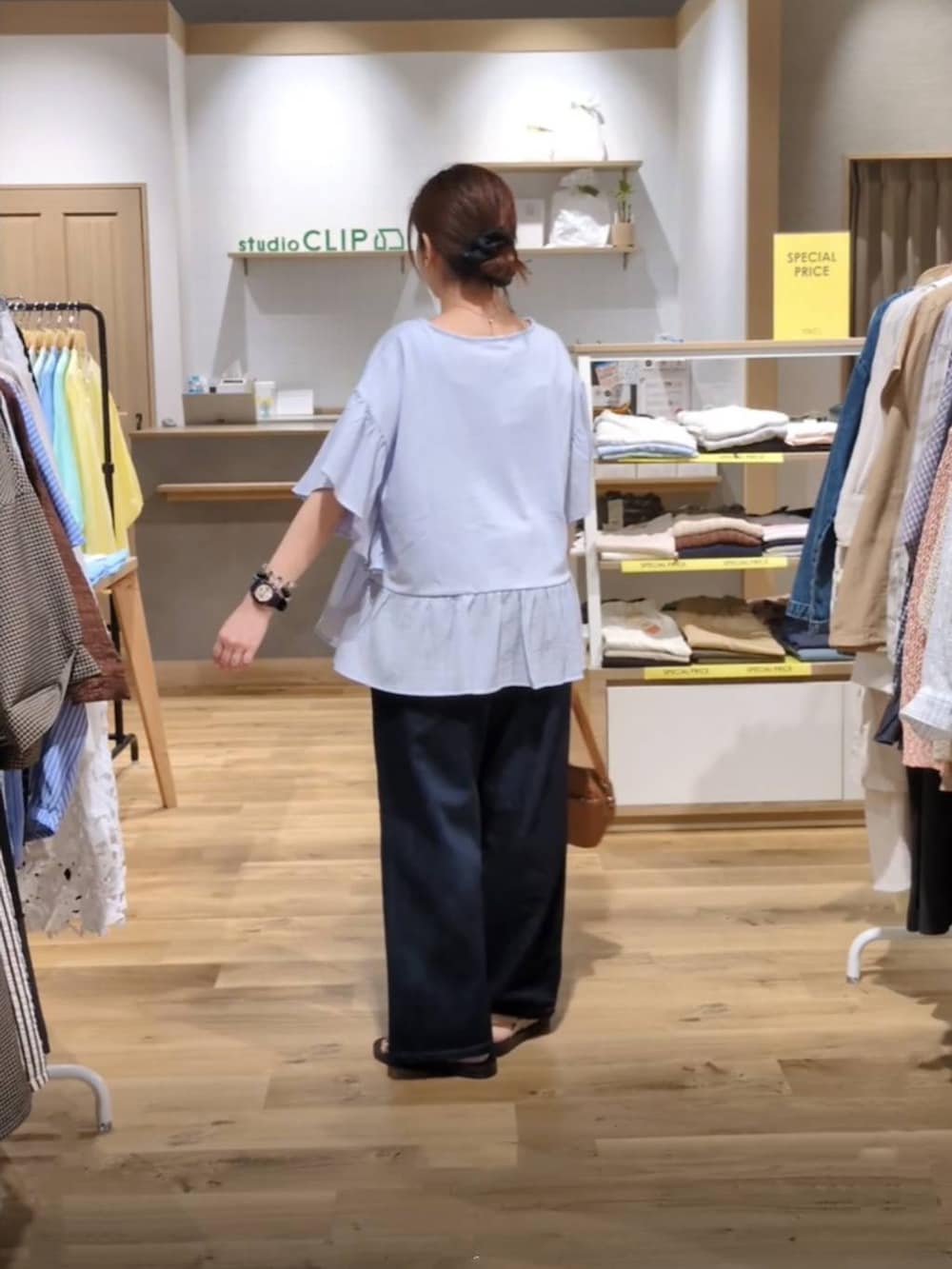 ブラウン系のショルダーバッグ、ゴールド系のサンダル、ブルー系のデニムパンツを着用したレディースの夏コーディネートの2枚目の写真