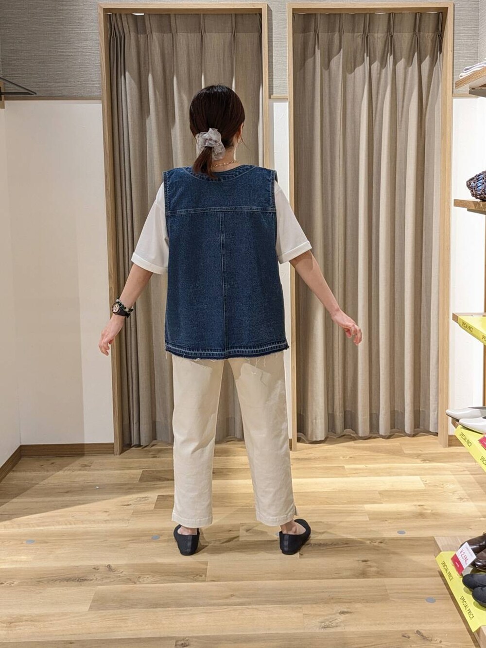 ブルー系のベスト、グレー系のその他パンツ、ブラウン系のショルダーバッグを着用したレディースの春コーディネートの2枚目の写真