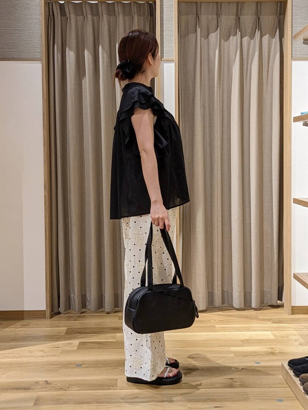ブラック系のシャツ/ブラウス、ブラック系のショルダーバッグ、ホワイト系のその他パンツを着用したレディースの夏コーディネートの2枚目の写真