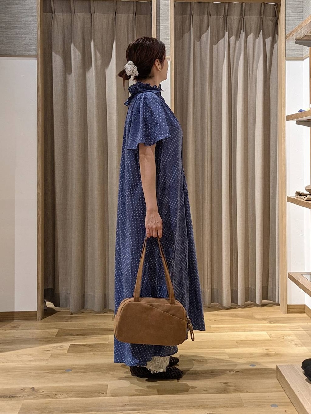 ブラウン系のショルダーバッグ、ベージュ系のデニムパンツ、ブラウン系のパンプスを着用したレディースの秋コーディネートの3枚目の写真
