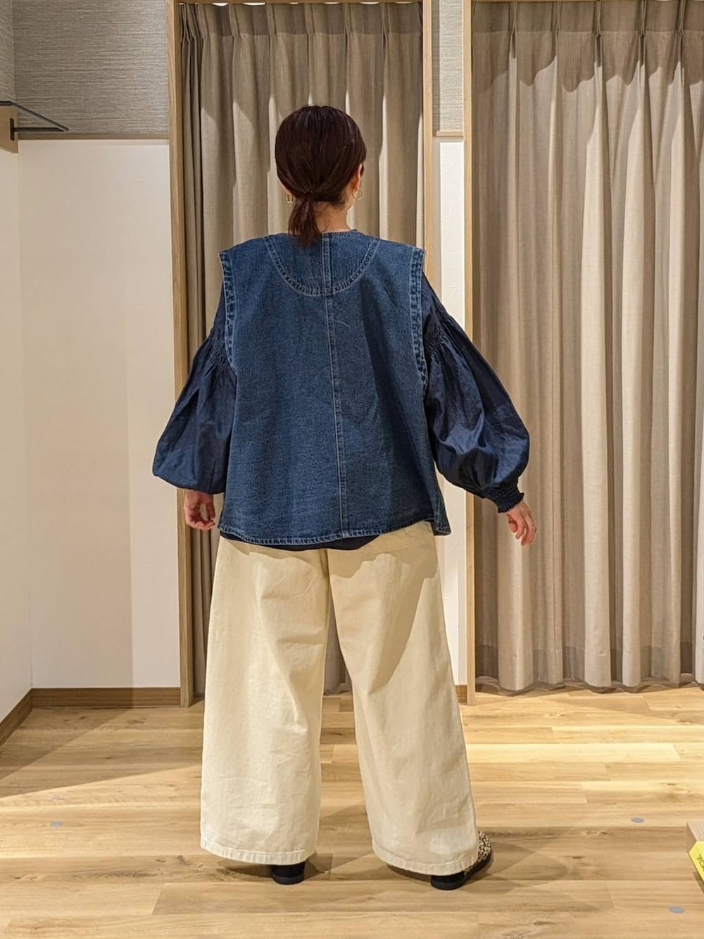 ブルー系のベスト、その他のスニーカー、イエロー系のチノパンツを着用したレディースの冬コーディネートの2枚目の写真