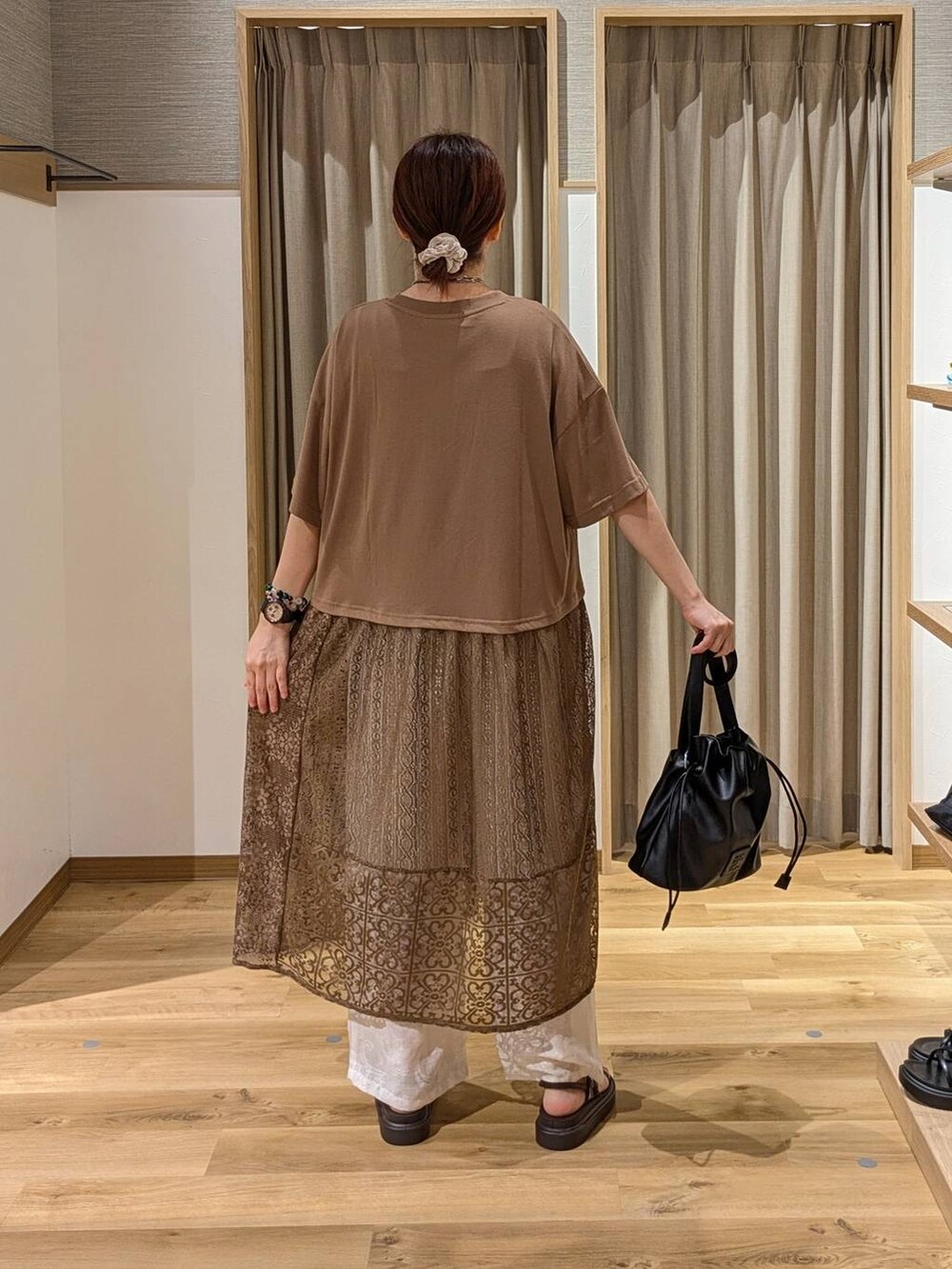 ブラウン系のサンダル、ブラック系のトートバッグ、ベージュ系のその他パンツを着用したレディースの夏コーディネートの2枚目の写真