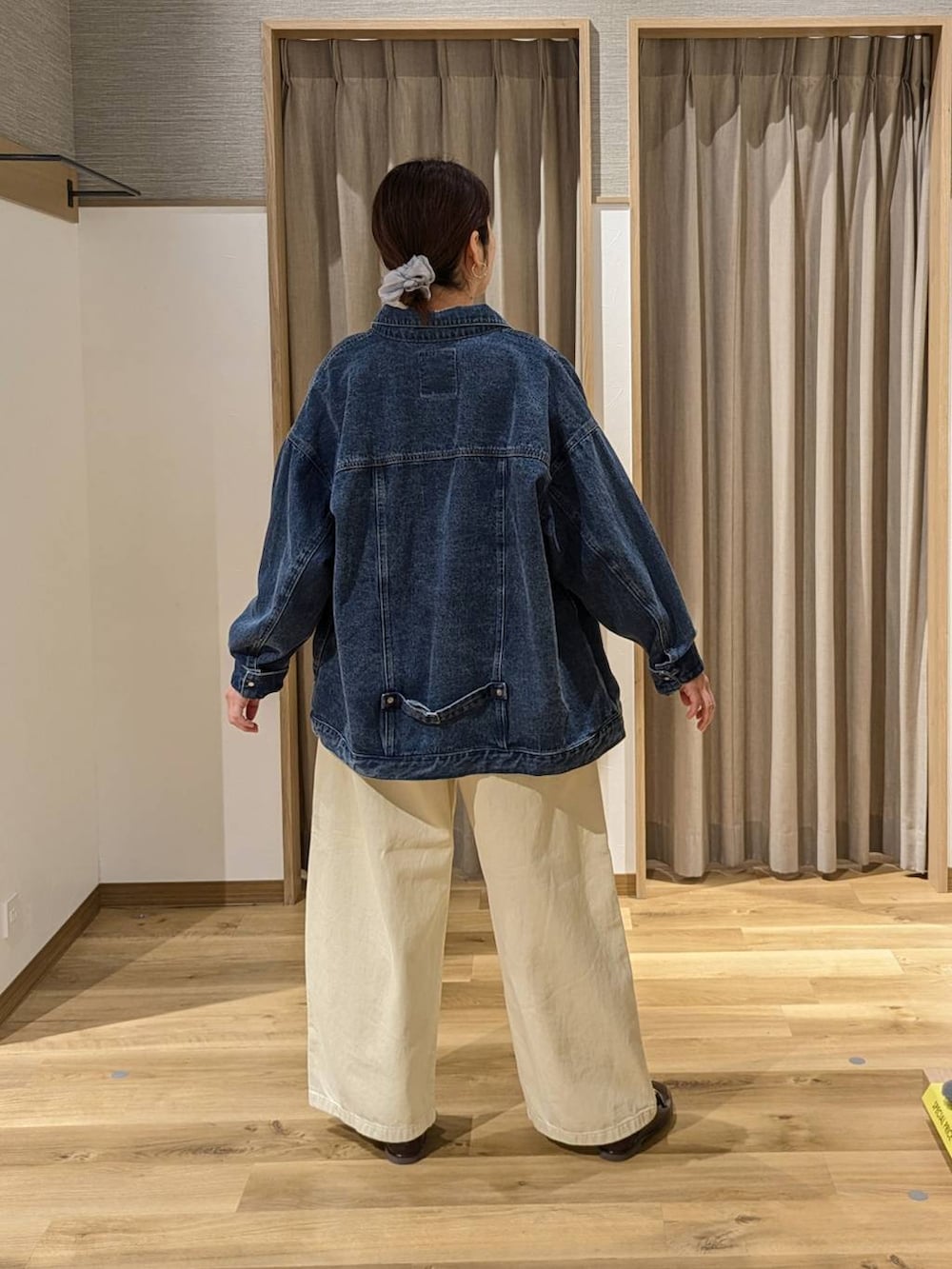 ブルー系のデニムジャケット、イエロー系のチノパンツ、ブラウン系のローファーを着用したレディースの冬コーディネートの2枚目の写真