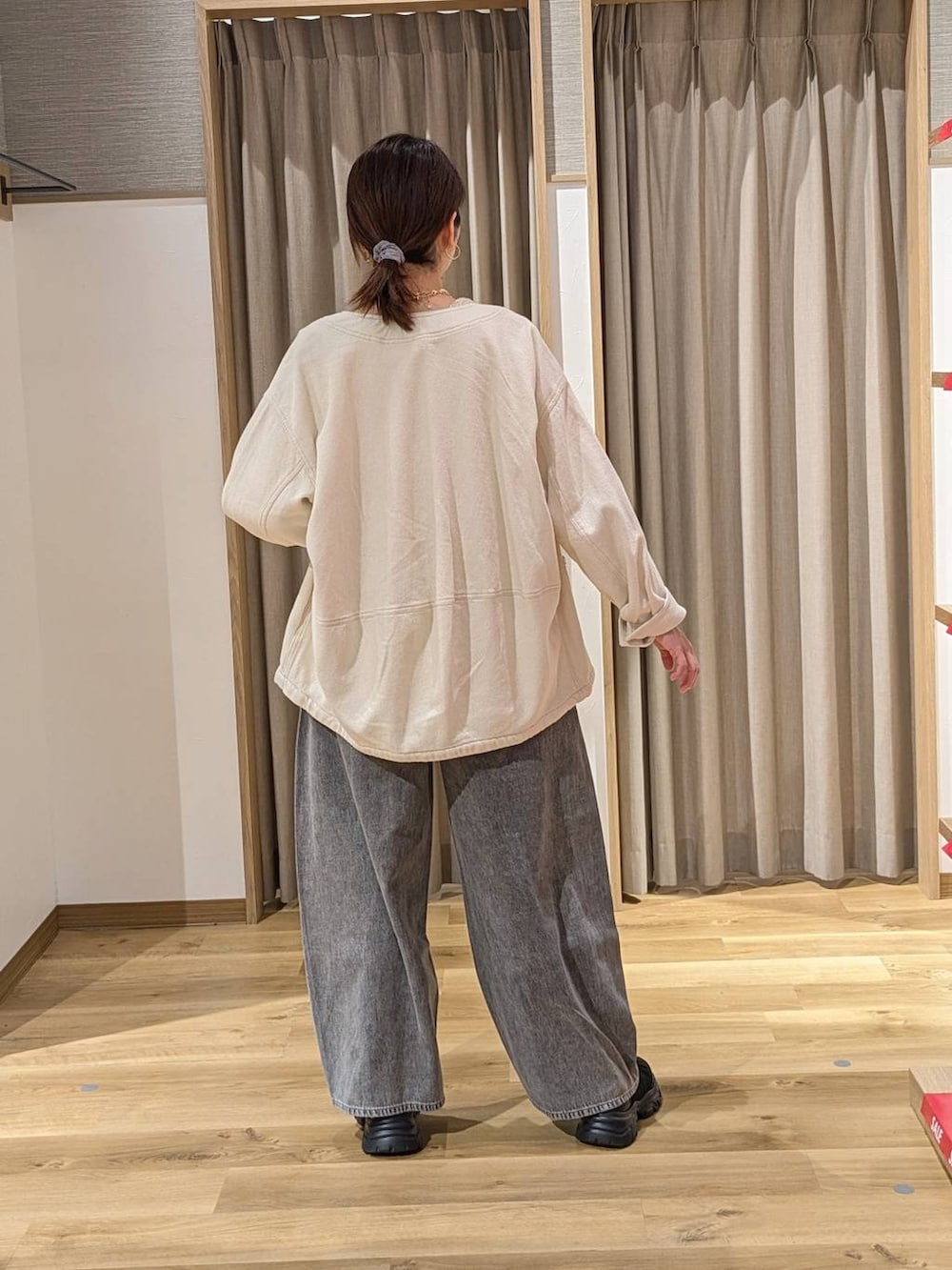 グレー系のデニムパンツ、ブラック系のスニーカー、ベージュ系のノーカラージャケットを着用したレディースの冬コーディネートの2枚目の写真