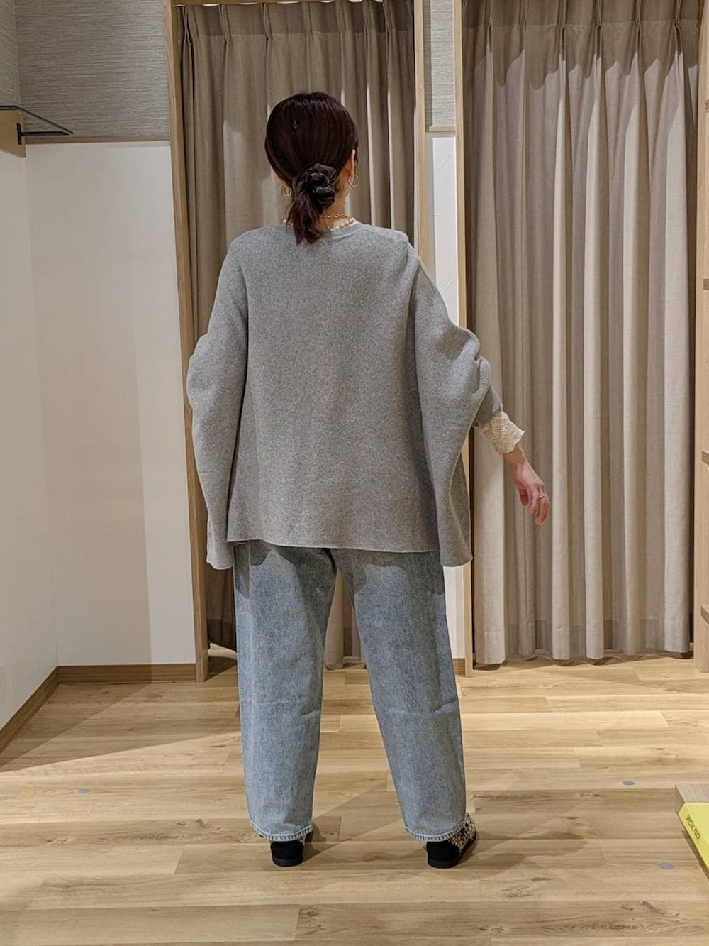 ブルー系のデニムパンツ、その他のスニーカー、ブラウン系のトートバッグを着用したレディースの冬コーディネートの2枚目の写真