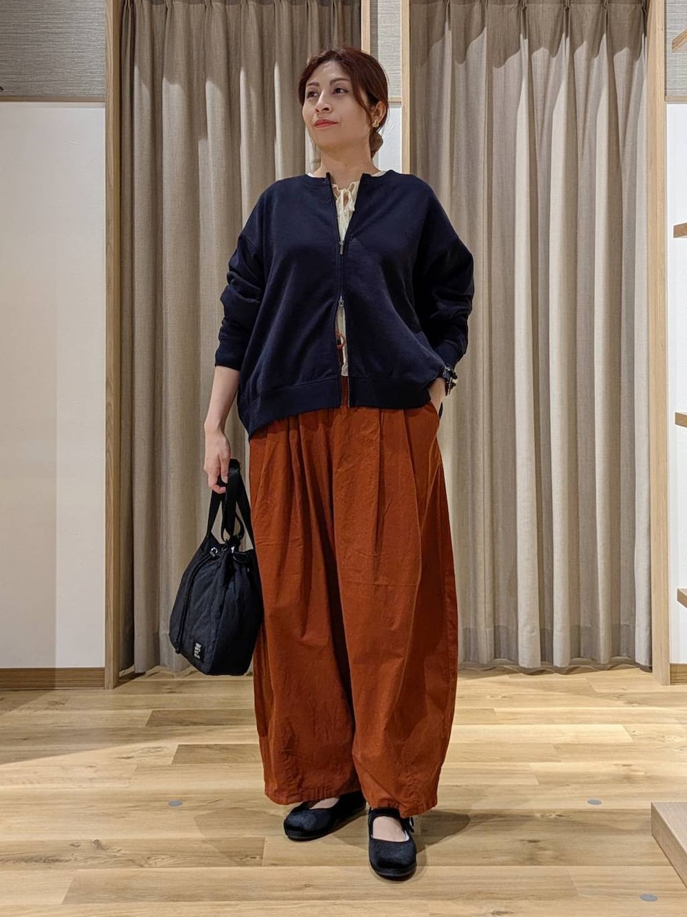 オレンジ系のその他パンツ、ブラック系のその他シューズ、ブルー系のスウェットを着用したレディースの秋コーディネートの3枚目の写真