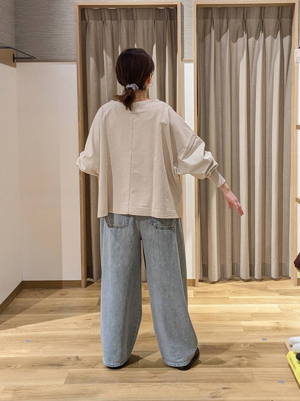 ブルー系のデニムパンツ、グレー系のTシャツ/カットソー、ベージュ系のトートバッグを着用したレディースの春コーディネートの2枚目の写真