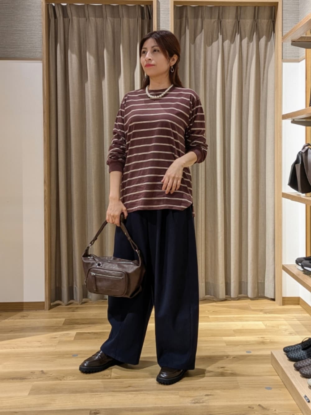 ブラウン系のTシャツ/カットソー、ブラウン系のローファー、ブルー系のその他パンツを着用したレディースの秋コーディネートの2枚目の写真