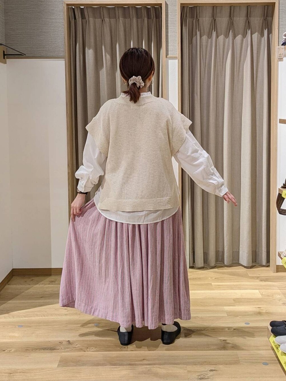 ピンク系のスカート、ホワイト系のシャツ/ブラウス、グレー系のパンプスを着用したレディースの春コーディネートの2枚目の写真