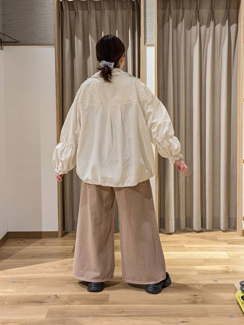 ベージュ系のデニムパンツ、ブラック系のスニーカー、ホワイト系のTシャツ/カットソーを着用したレディースの春コーディネートの2枚目の写真