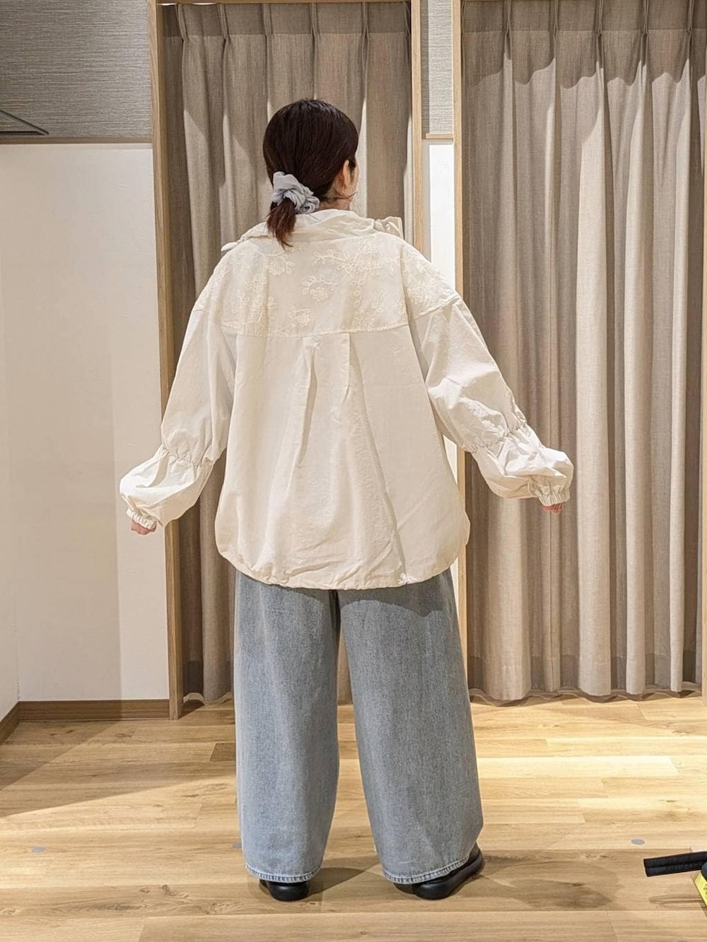 ブラック系のサンダル、ブルー系のデニムパンツ、ベージュ系のブルゾンを着用したレディースの春コーディネートの2枚目の写真